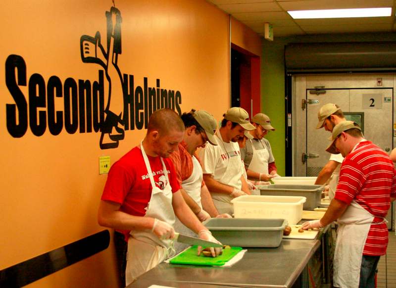 a group of men in aprons preparing food