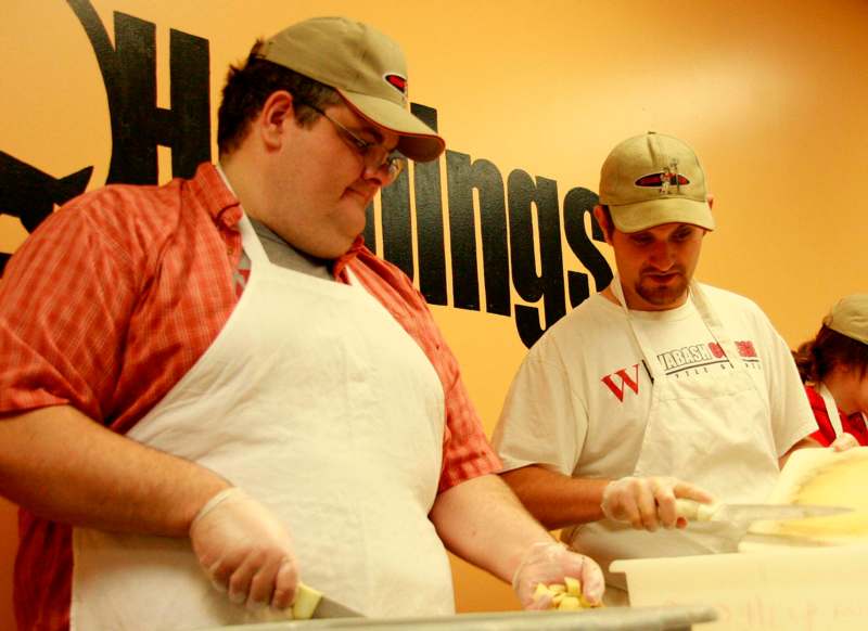 a couple of men preparing food