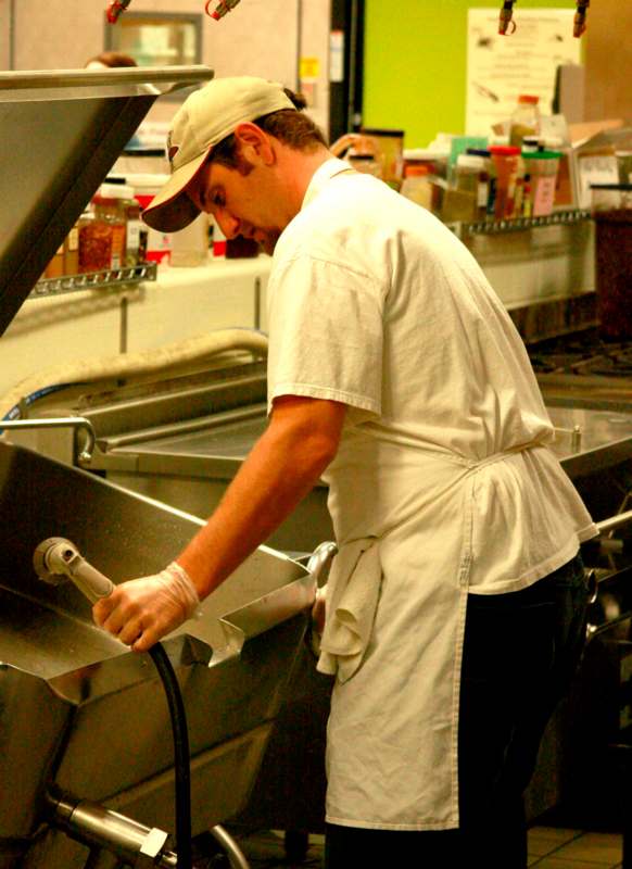 a man in a white apron working in a kitchen