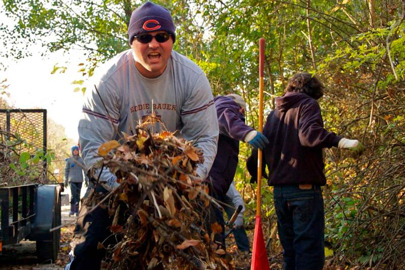 a man pushing a pile of leaves