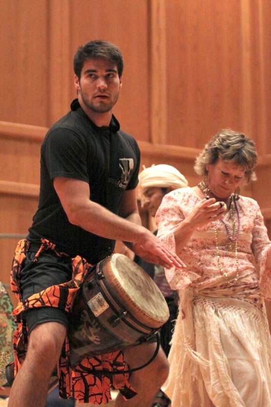 a man playing a drum with a woman