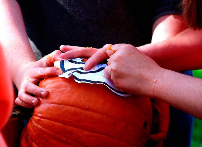 a person's hands peeling a pumpkin