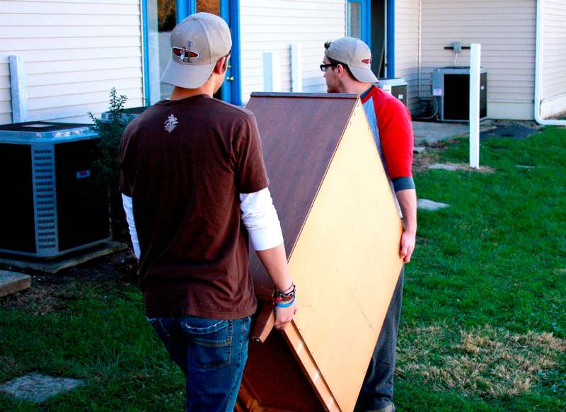 a couple of men carrying a large box