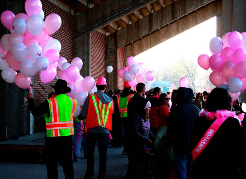 a group of people in safety vests holding balloons