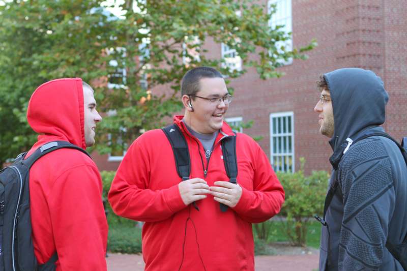 a group of men wearing red hoodies and backpacks