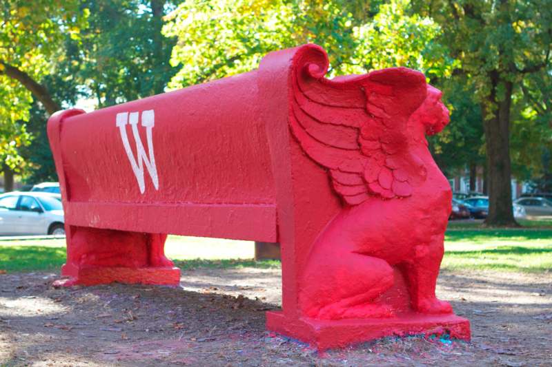 a red bench with a winged animal and a w on it