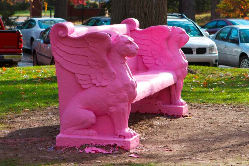 a pink bench with a lion statue