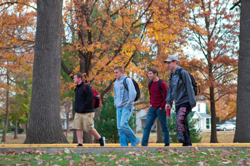 a group of young men walking on a sidewalk