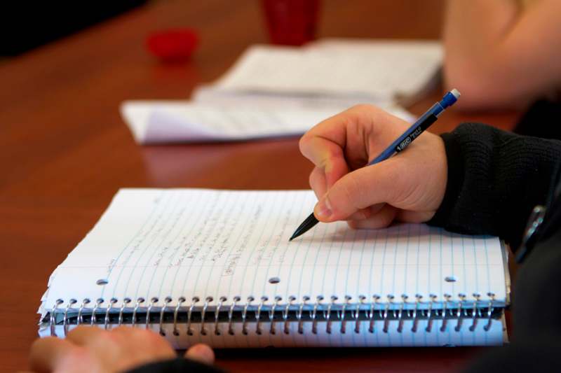 a person writing on a notebook