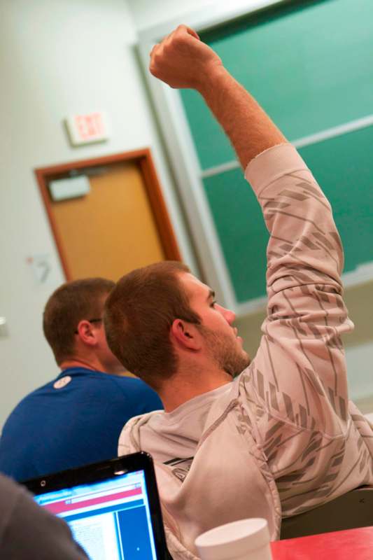 a man raising his hand in a classroom
