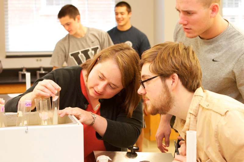 a group of people looking at a test tube