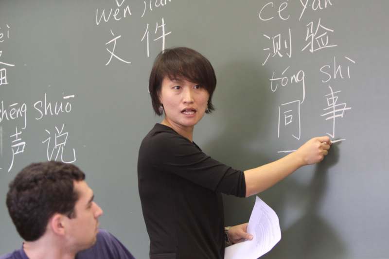 a woman pointing at a blackboard