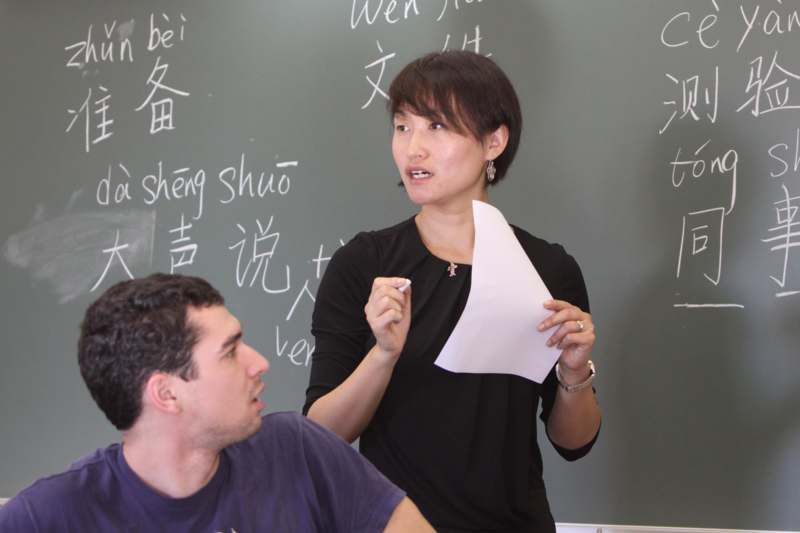 a woman holding a piece of paper in front of a man sitting in a chair
