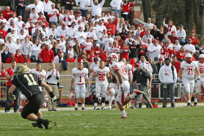 a football player running on a field with a crowd watching