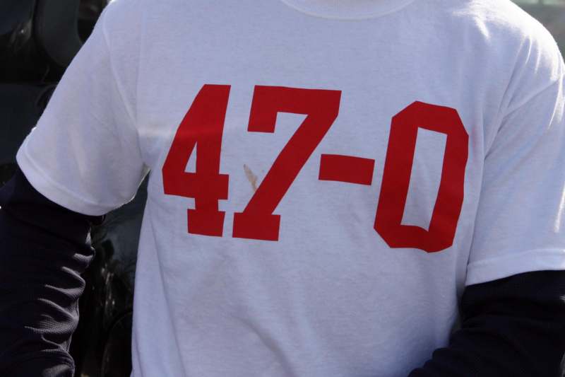 a person wearing a white shirt with red numbers