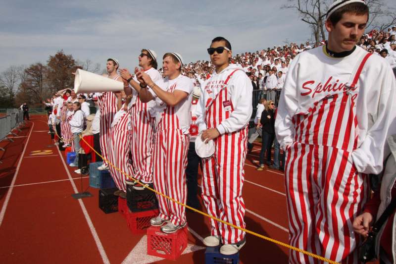a group of people in striped overalls standing on a track