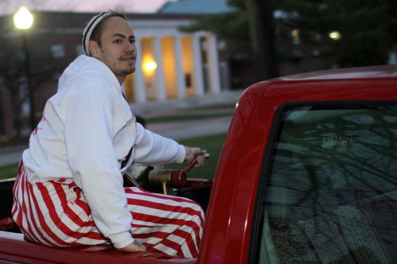 a man in a white and red striped outfit sitting in a red truck