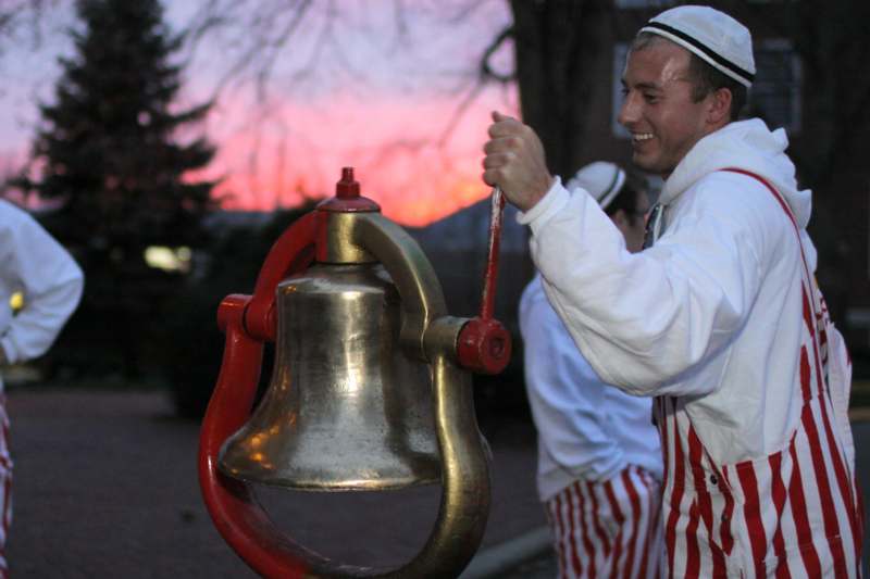 a man holding a bell
