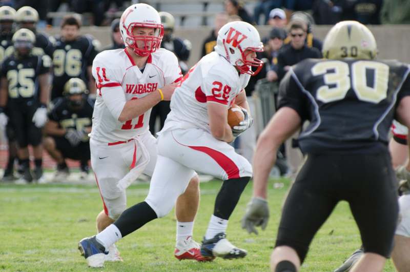 two football players running with a football