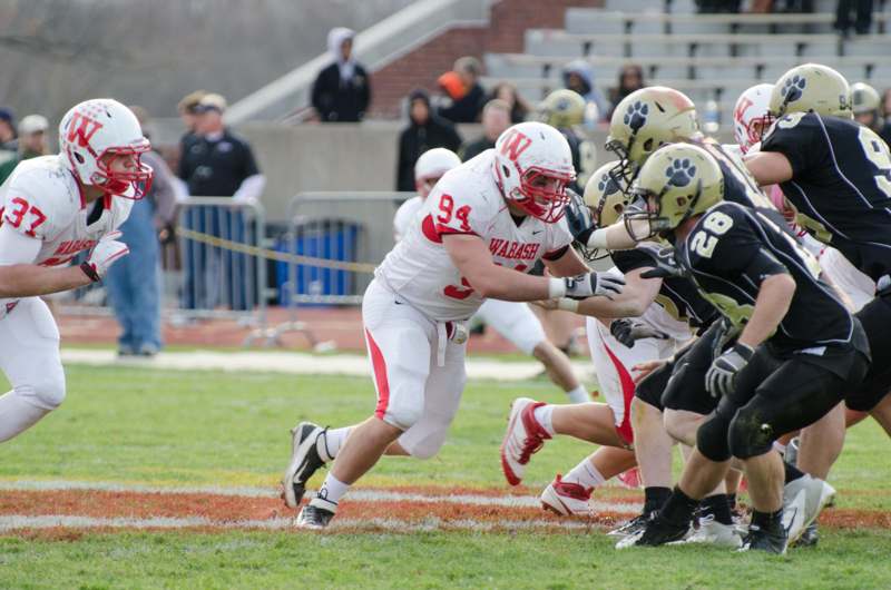 a football player in a red uniform running with other players