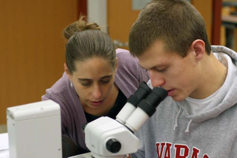 a man and woman looking through a microscope
