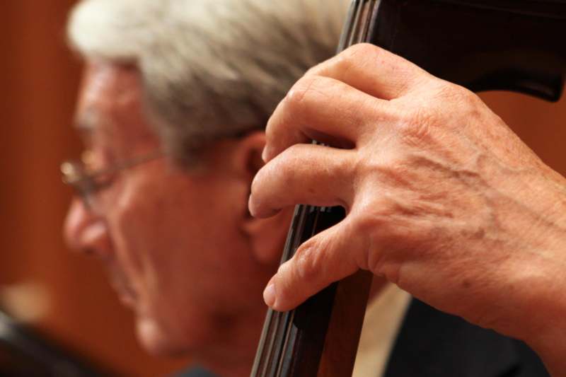 a close-up of a man playing a cello