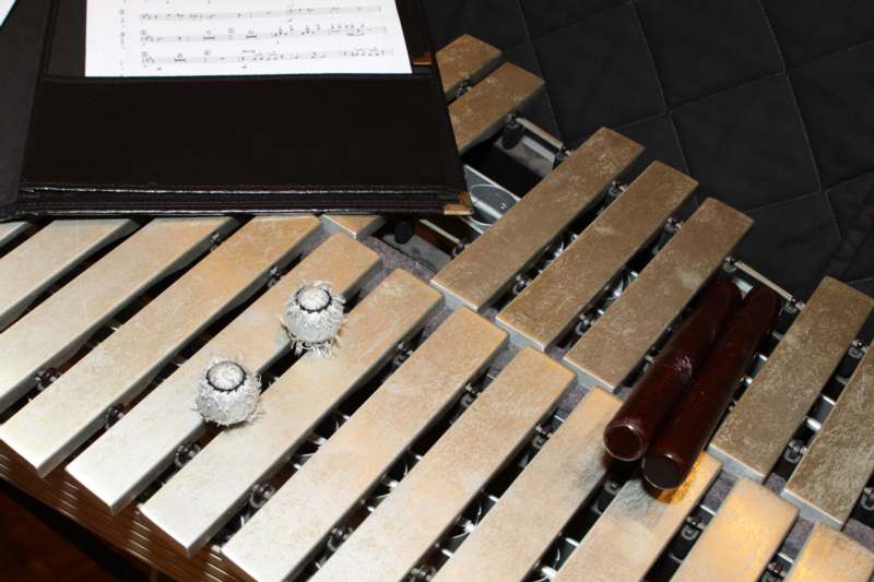 a xylophone with a pair of sticks and a note