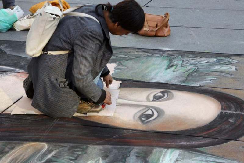 a woman drawing on the ground