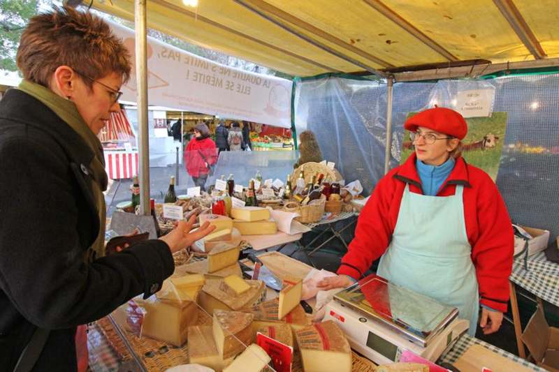 a woman selling cheese at a market
