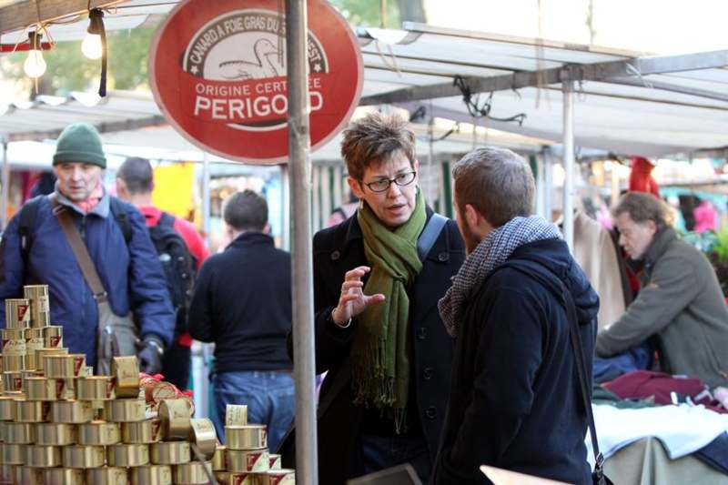 a woman talking to a man at a market