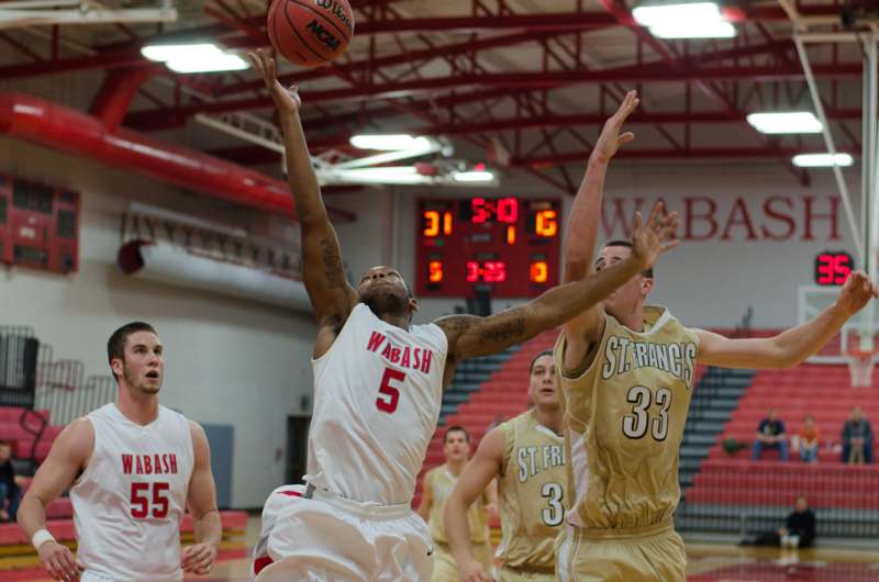 a basketball player in a white uniform jumping to block a basketball