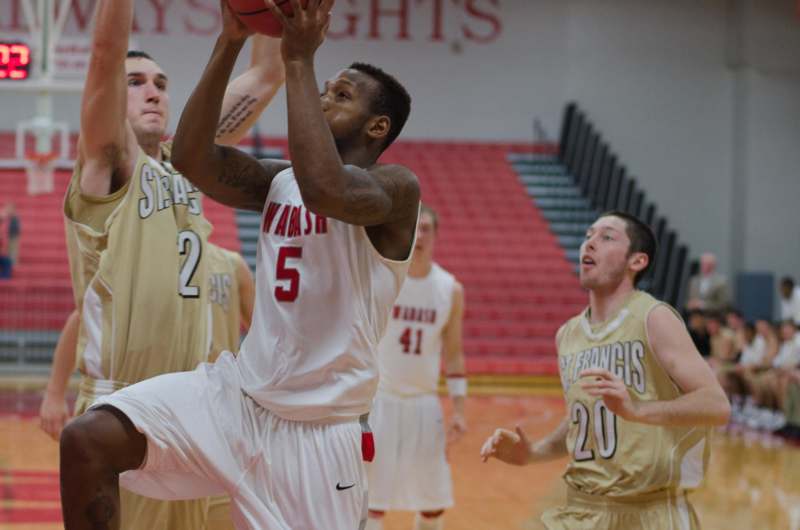 a basketball player in a white uniform jumping to shoot a basketball