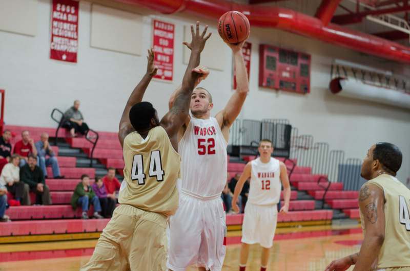 a basketball player reaching for a ball