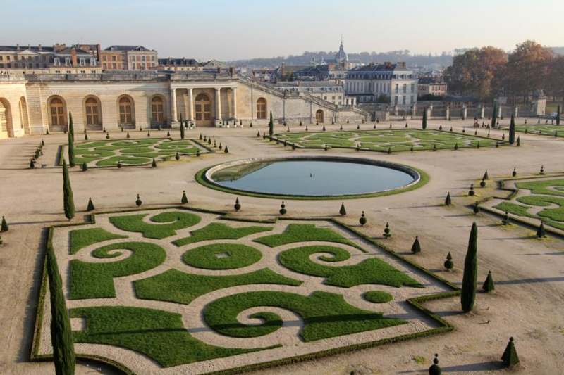 a large courtyard with a pond and a large building