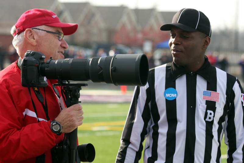 a man with a camera and a referee