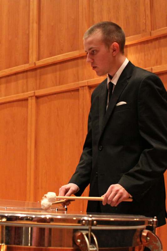 a man in a suit holding chopsticks