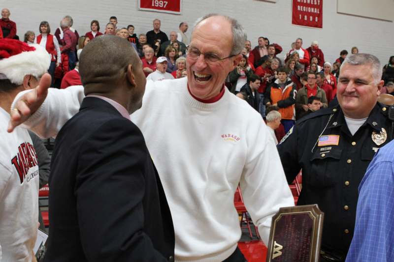 a man laughing while another man is holding a plaque