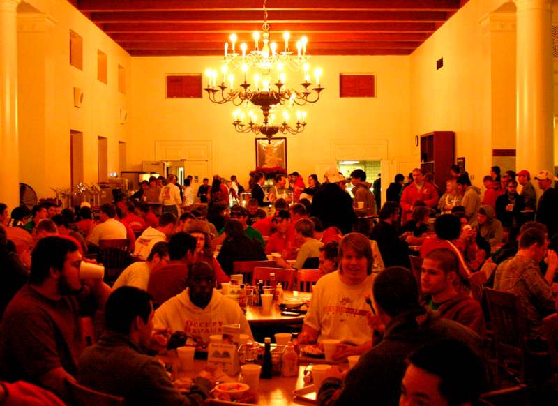 a group of people sitting at tables in a room with chandeliers