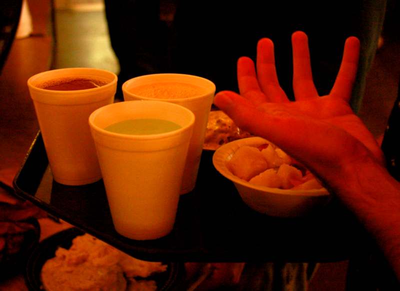 a hand reaching out to a tray of food