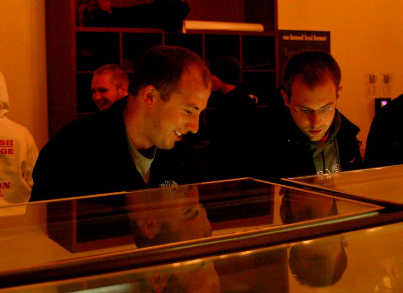 a group of men looking at a display case