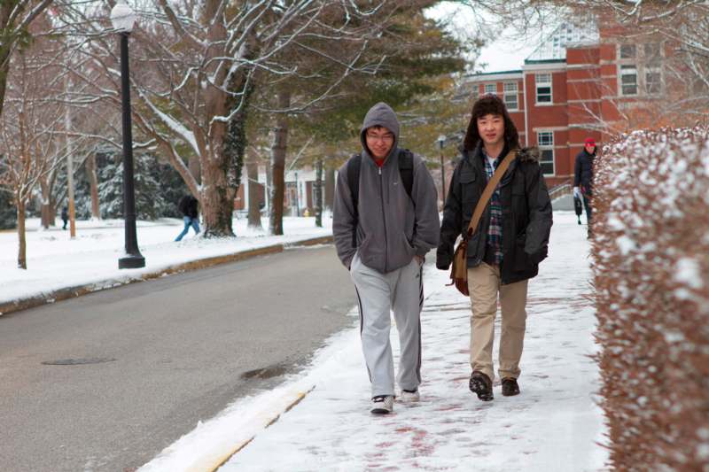 two men walking on a snowy sidewalk