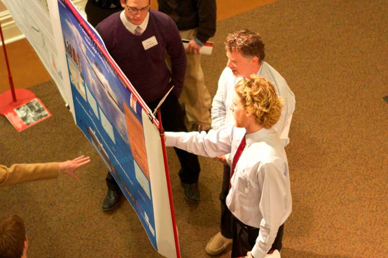 a group of people looking at a poster