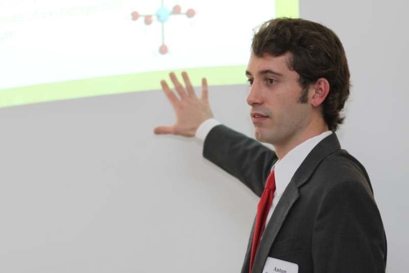 a man in a suit pointing at a screen