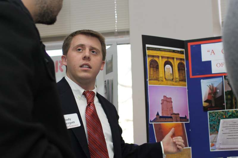 a man in a suit pointing at a poster