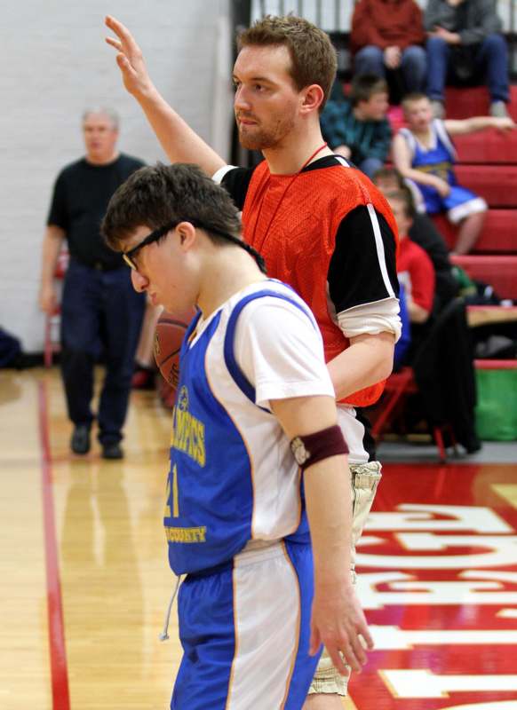 a man standing next to a basketball player