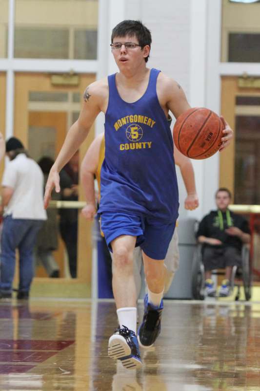 a man in a blue tank top running with a basketball