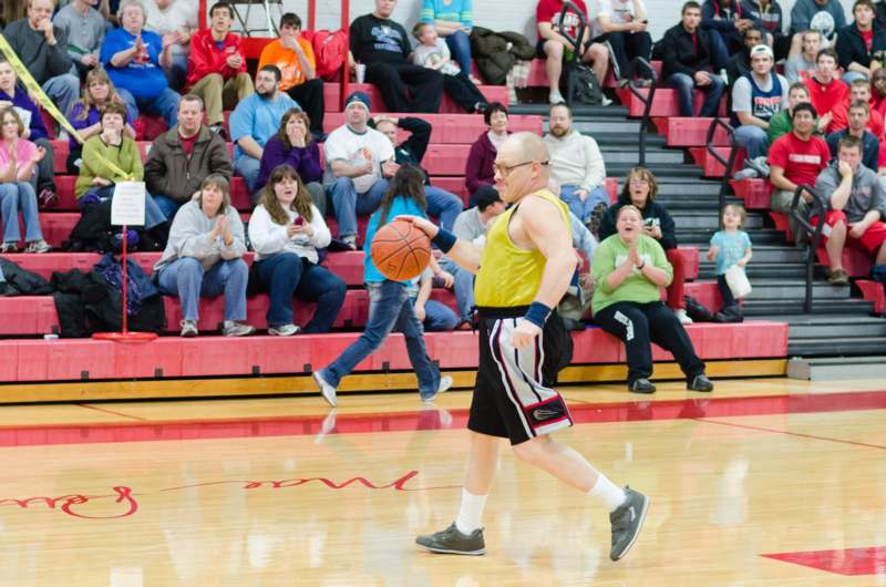 a man playing basketball with a crowd watching