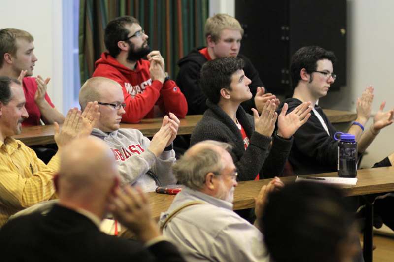 a group of people clapping at a meeting