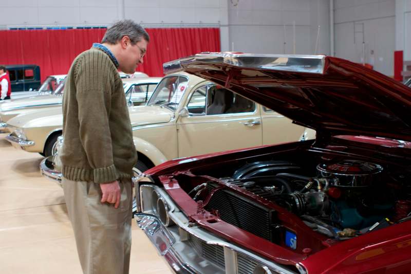 a man looking at a car with its hood open