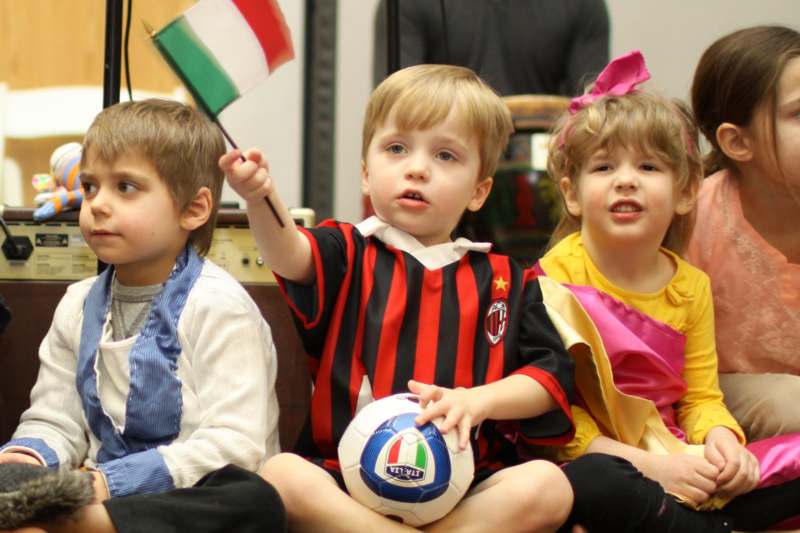 a group of children holding a flag and a football ball